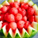 Watermelon balls being placed inside the watermelon Ball bowl