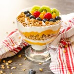 Tropical Granola Breakfast in a glass bowl with red and white striped towel