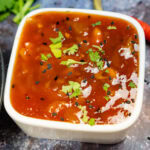 Homemade Mango Chutney in a white dish with fresh chopped coriander sprinkled over the top