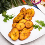 Slices of Fried Dodo on a white plate with parsley leaves on the side