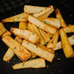Honey Roast Parsnips Recipe with fresh thyme, salt and pepper sprinkled over the top