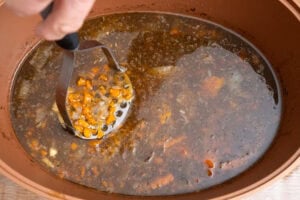 Mashing up the vegetables with a masher in a pot