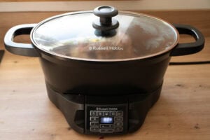 A Russell hobs slow cooker with a beef shin cooking inside with the lid placed on top