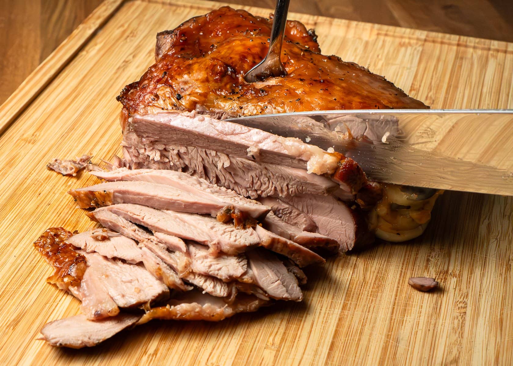Slicing turkey thigh on a wooden chopping board