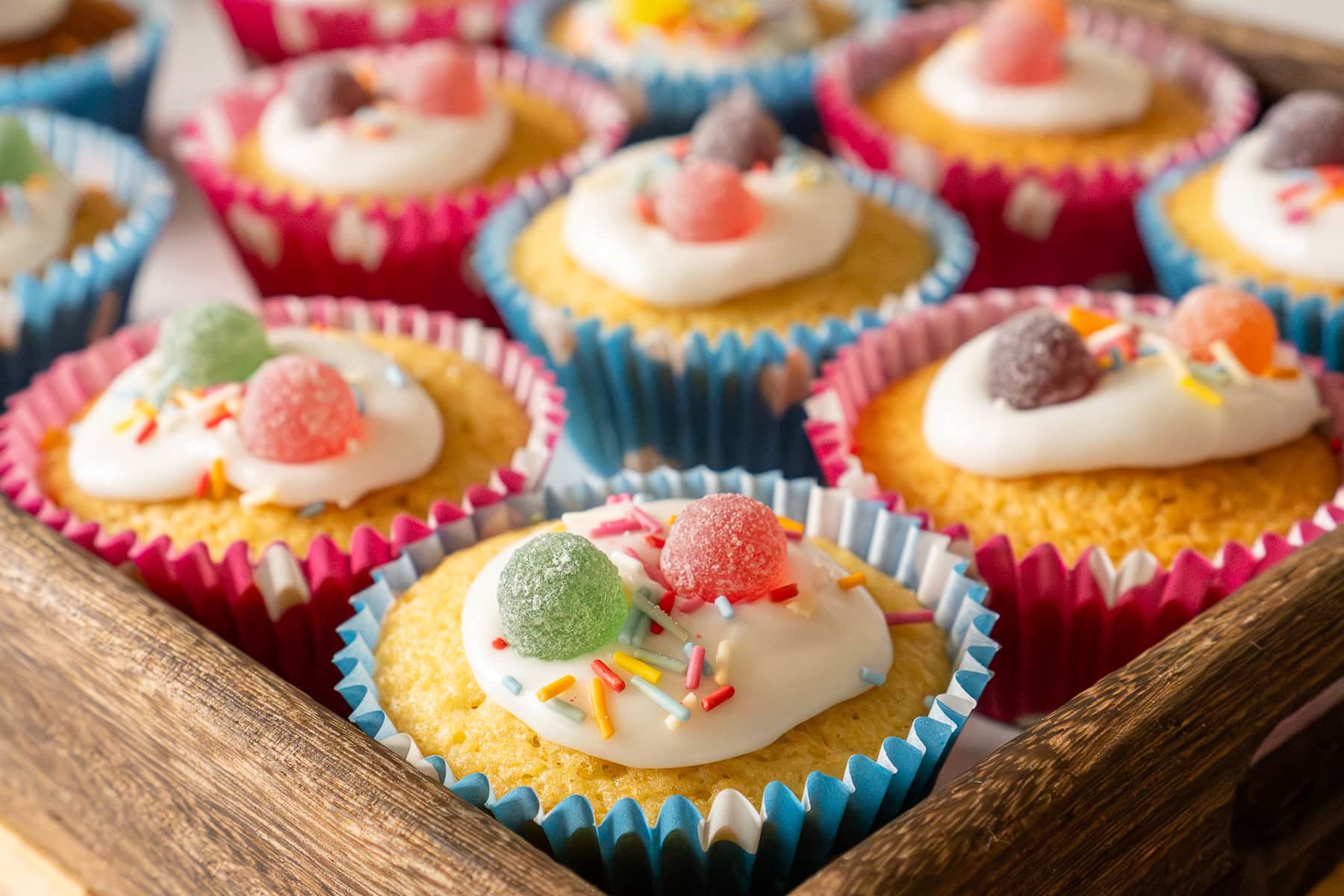 Fairy cakes coated in icing, sprinkles and sweets