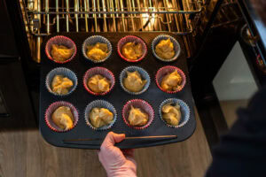 Twelve fairy cakes going into the oven