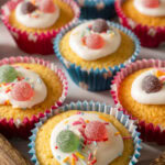 Fairy cakes decorated in icing, colourful sprinkles and sweets