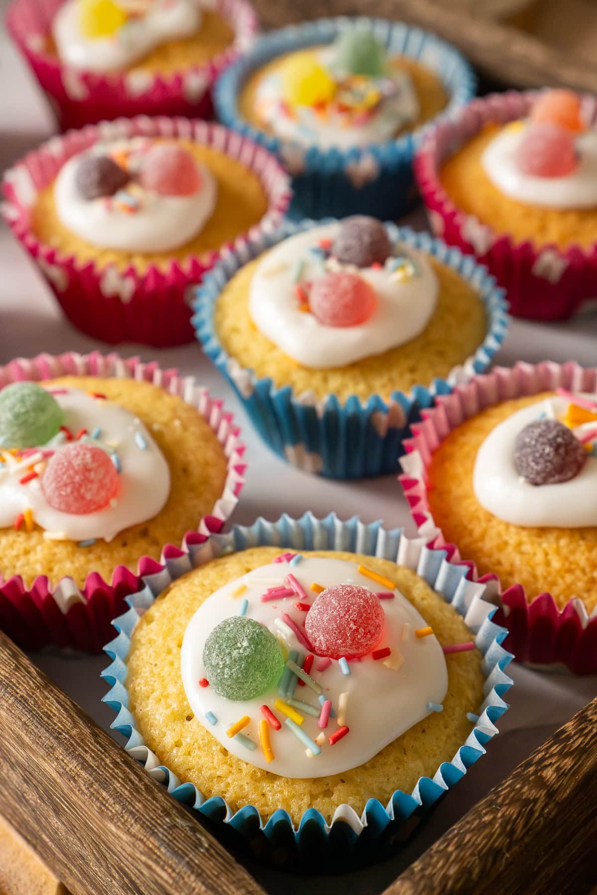 Fairy cakes decorated in icing, colourful sprinkles and sweets