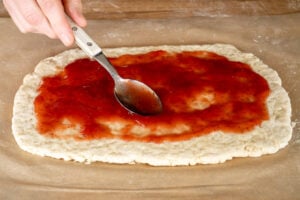 Spooning the strawberry jam onto the suet dough