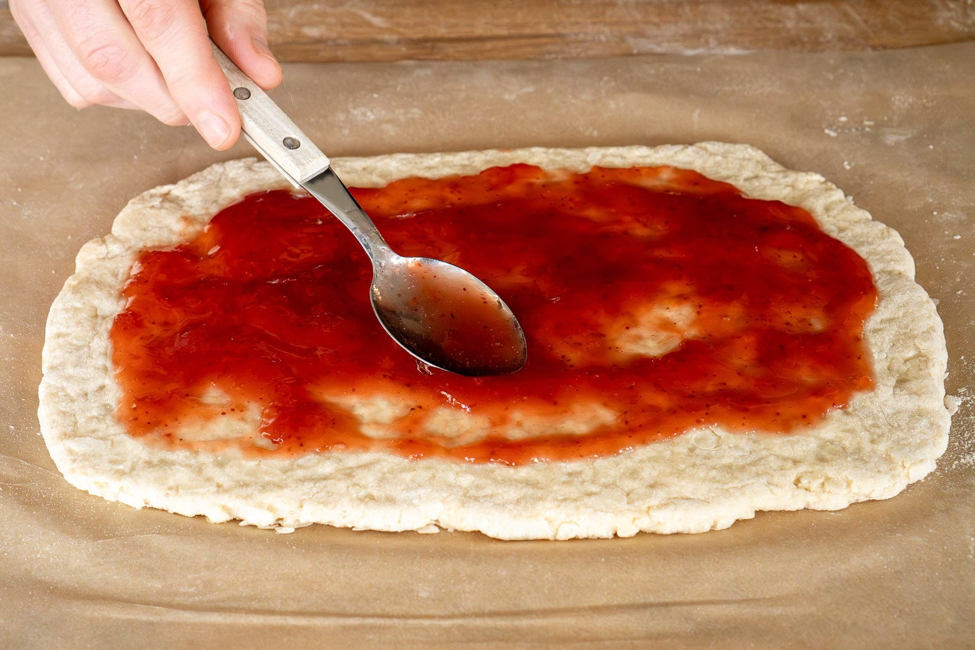 Spooning the strawberry jam onto the suet dough