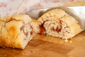 A slice of jam roly poly with jam oozing out