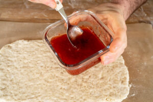 Strawberry jam in a glass container with spoon