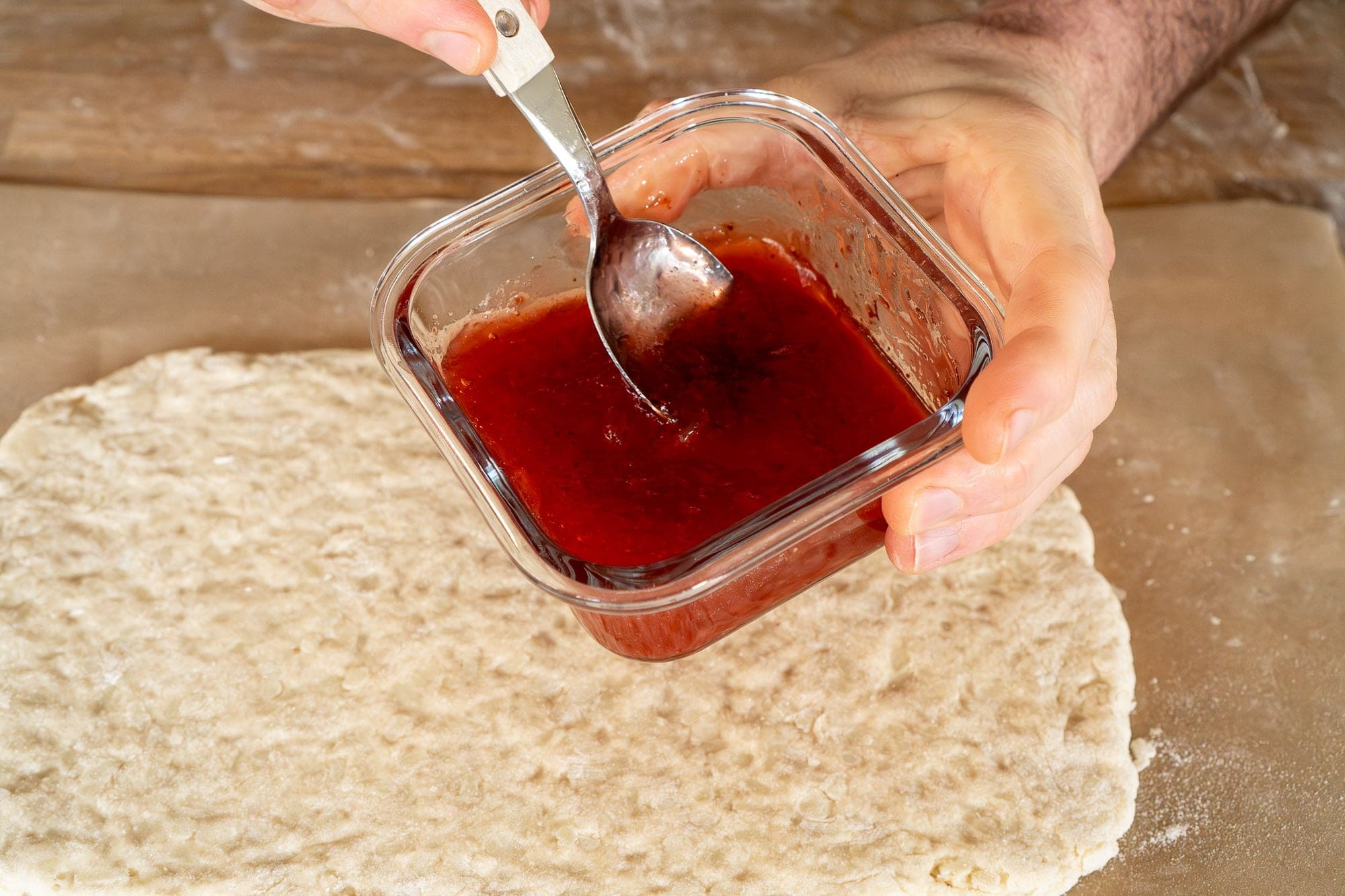 Strawberry jam in a glass container with spoon