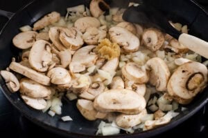 Chopped onion, sliced mushrooms and garlic in a pan cooking