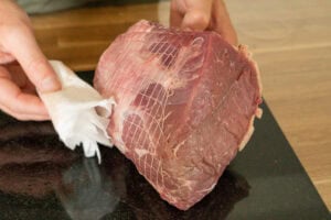Patting down top rump beef joint
