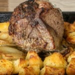 Roast top rump beef cooked to medium with roast potatoes before the beef is removed to rest.
