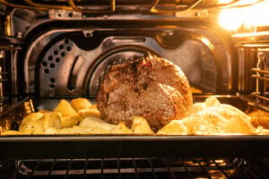 roast beef and potatoes in the oven on one tray
