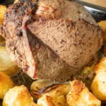 Top rump beef roasted sitting on onion quarters with crispy roast potatoes