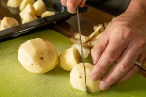Chopping peeled potatoes for roasting