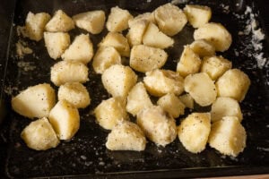 Parboiled potatoes shaken in a tray to rough up the edges for crispy roast potatoes.