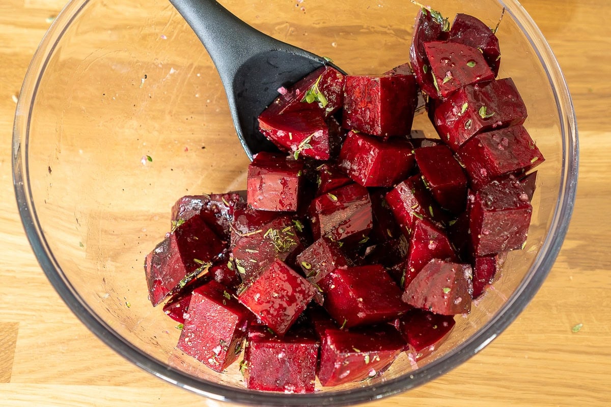 Beetroot cubes in bowl with herb seasoning.